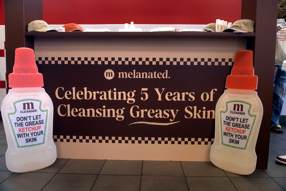 “Celebrating 5 Years of Cleansing Greasy Skin” banner between two giant bottles
