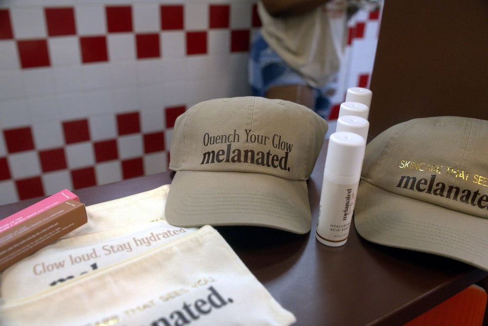 Melanated caps and a cleanser on the merch table