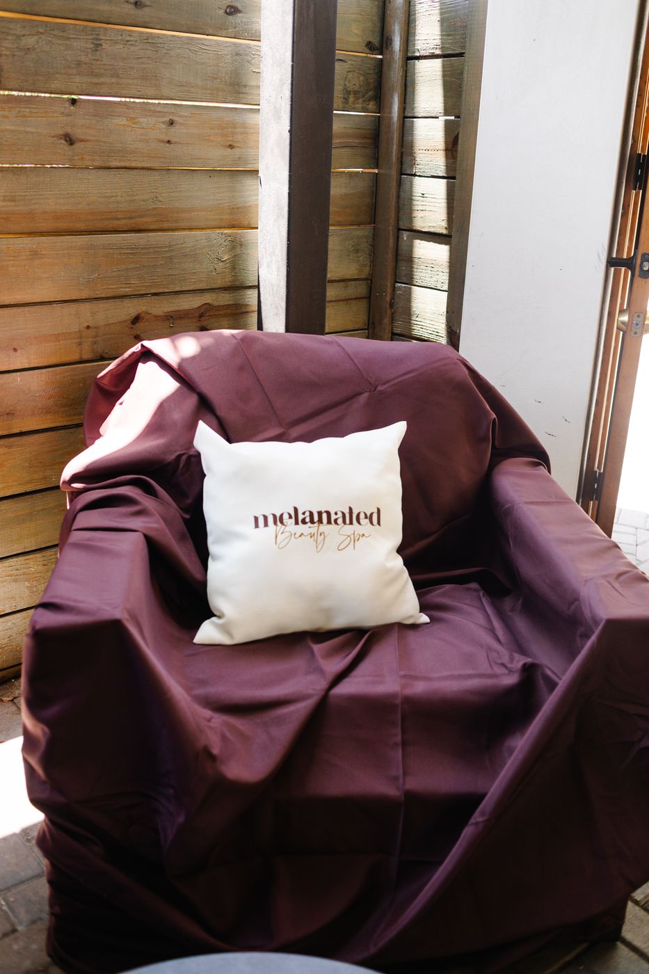 Melanated pillow on a draped lounge chair