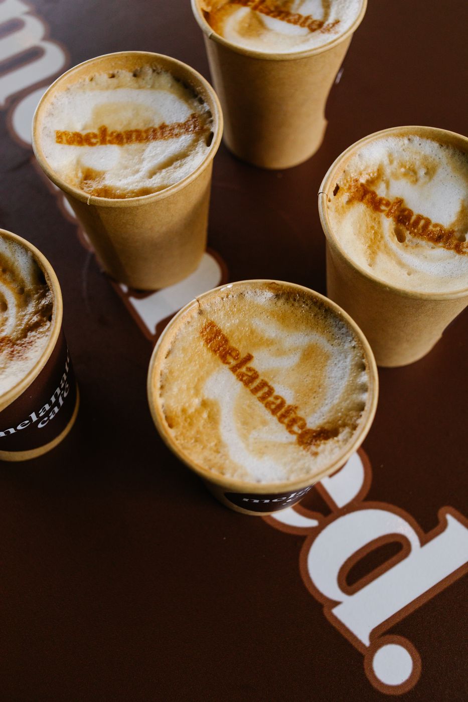 Latte art stamped with the Melanated logo