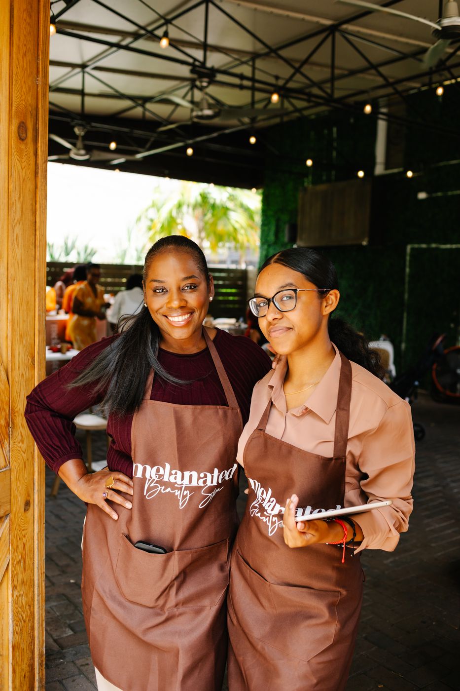 Two baristas in Melanated aprons