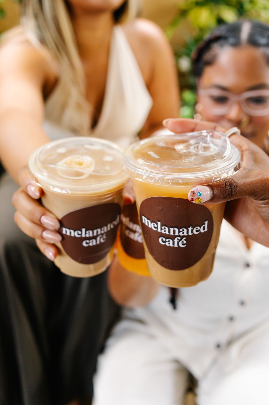 Guests toasting with Melanated Café iced coffees
