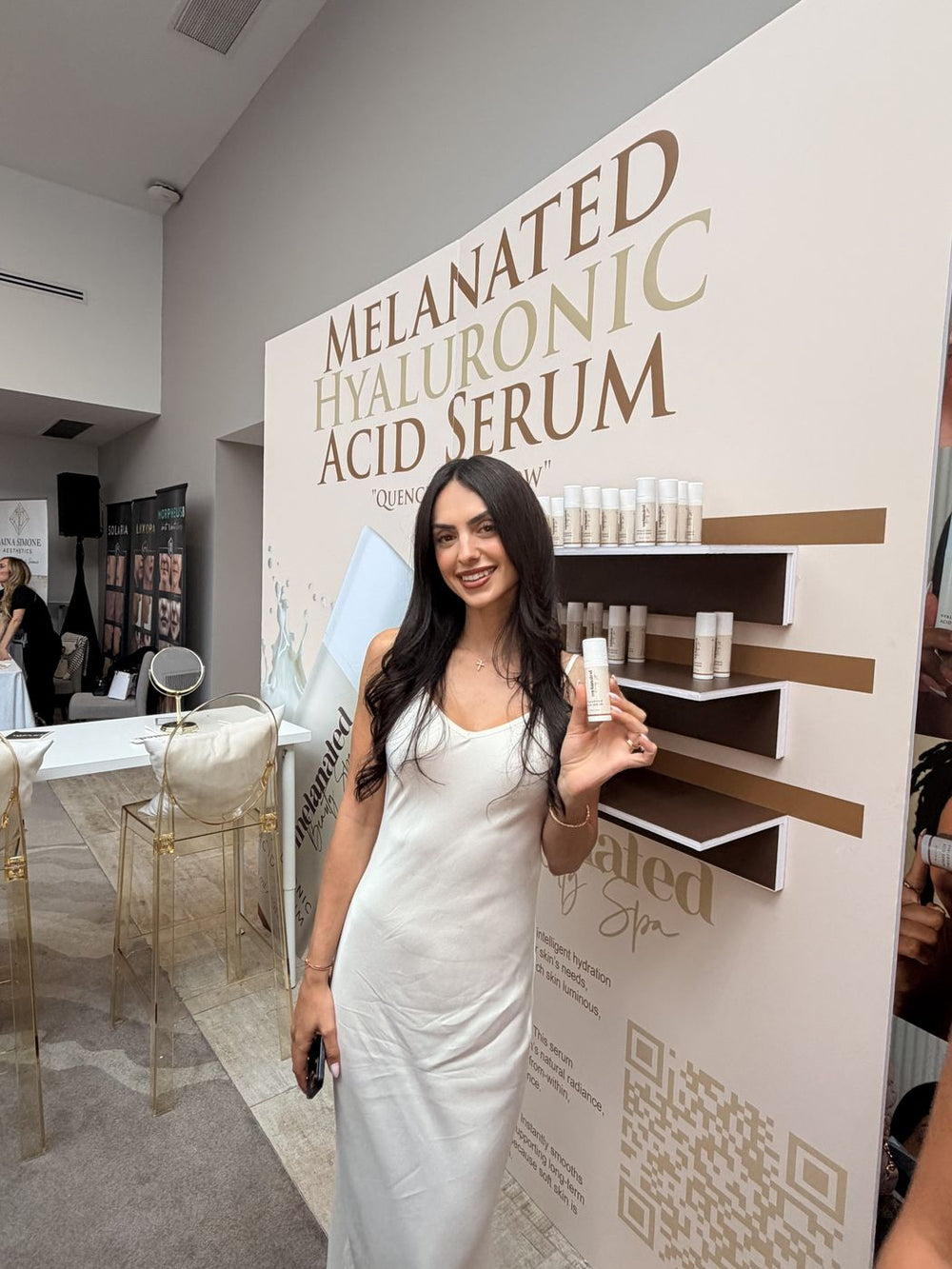 Guest in a white slip dress holding the serum