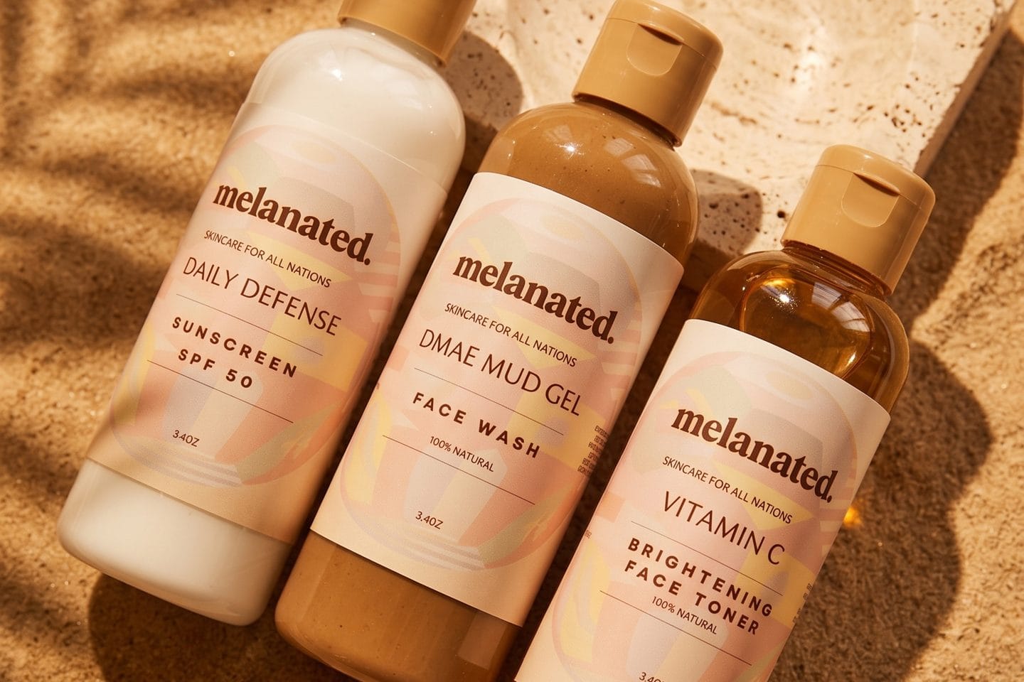 Facial glow set bottles angled on warm sand with palm shadows